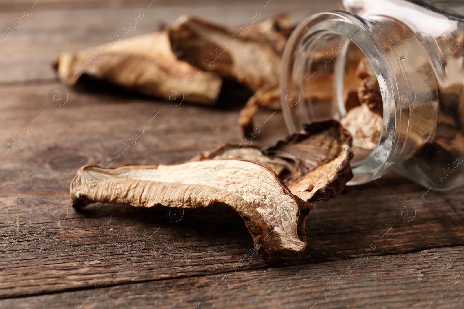 Photo of Composition of dried mushrooms and glassware on table, closeup