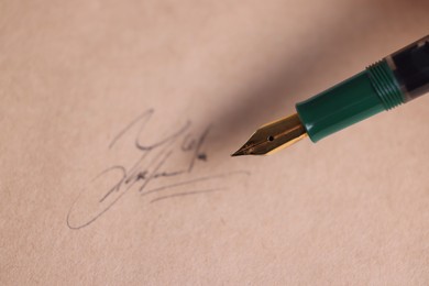 Photo of Fountain pen and signature on sheet of paper, closeup