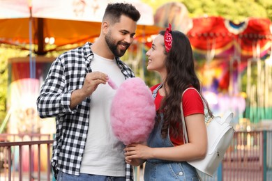 Photo of Happy couple with cotton candy at funfair