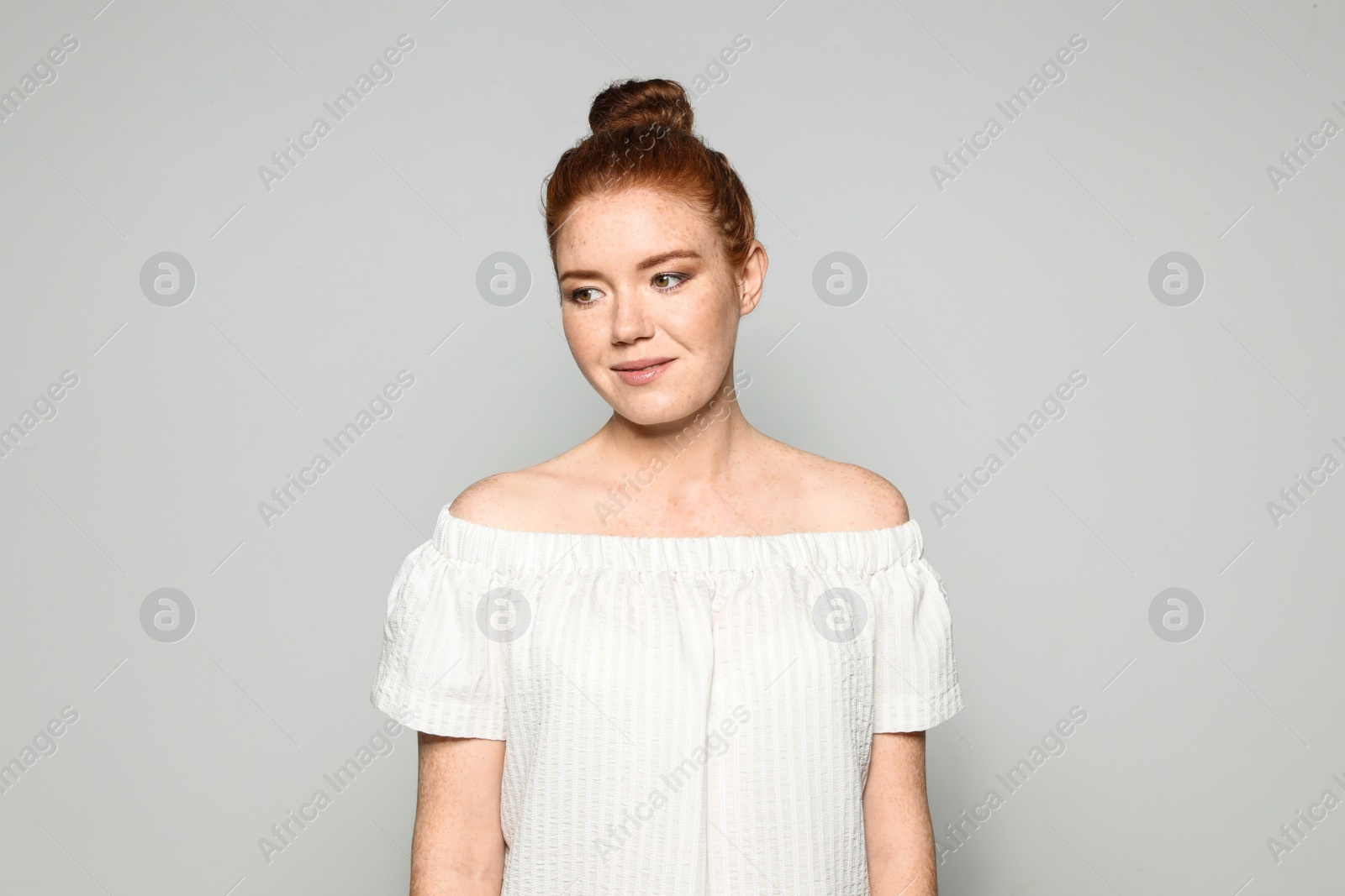 Photo of Portrait of young woman with beautiful face on grey background