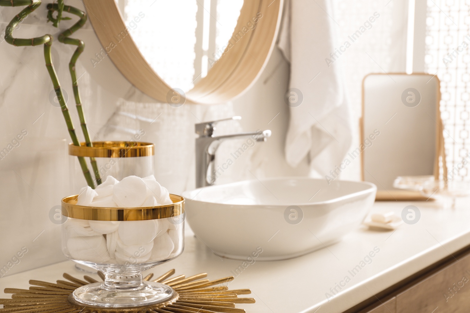 Photo of Decorative jar with cotton pads on modern countertop in bathroom interior