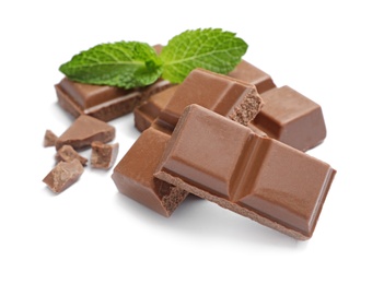 Pieces of milk chocolate with mint on white background