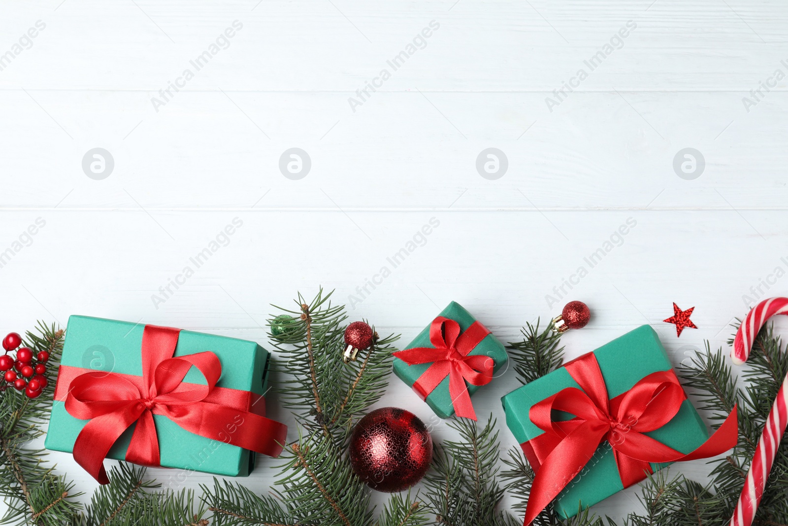 Photo of Flat lay composition with gift boxes and Christmas decorations on white wooden table, space for text