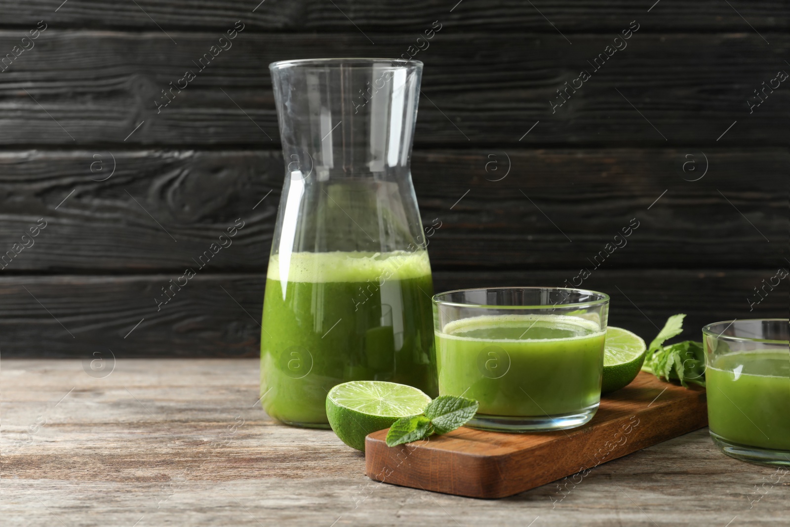 Photo of Glassware with delicious detox juice and ingredients on table