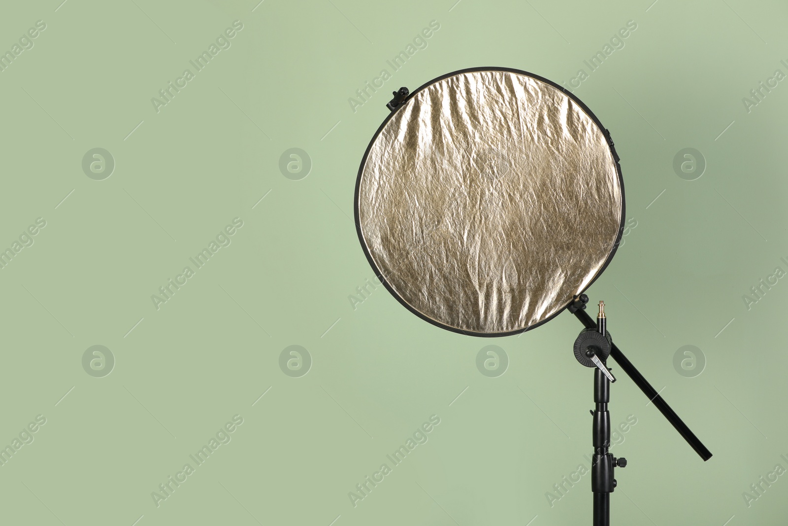 Photo of Studio reflector on pale green background, space for text. Professional photographer's equipment