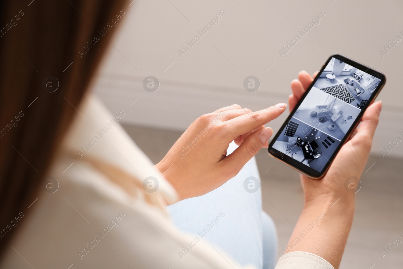 Image of Woman monitoring modern cctv cameras on smartphone indoors, closeup. Home security system