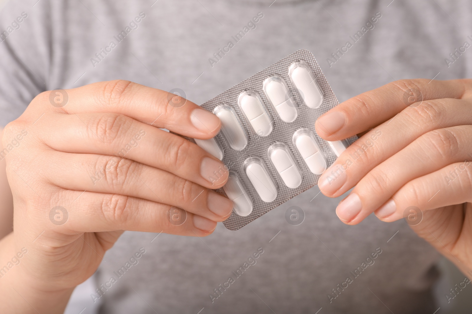 Photo of Woman holding blister of white pills, closeup