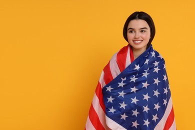 Photo of 4th of July - Independence Day of USA. Happy girl with American flag on yellow background, space for text