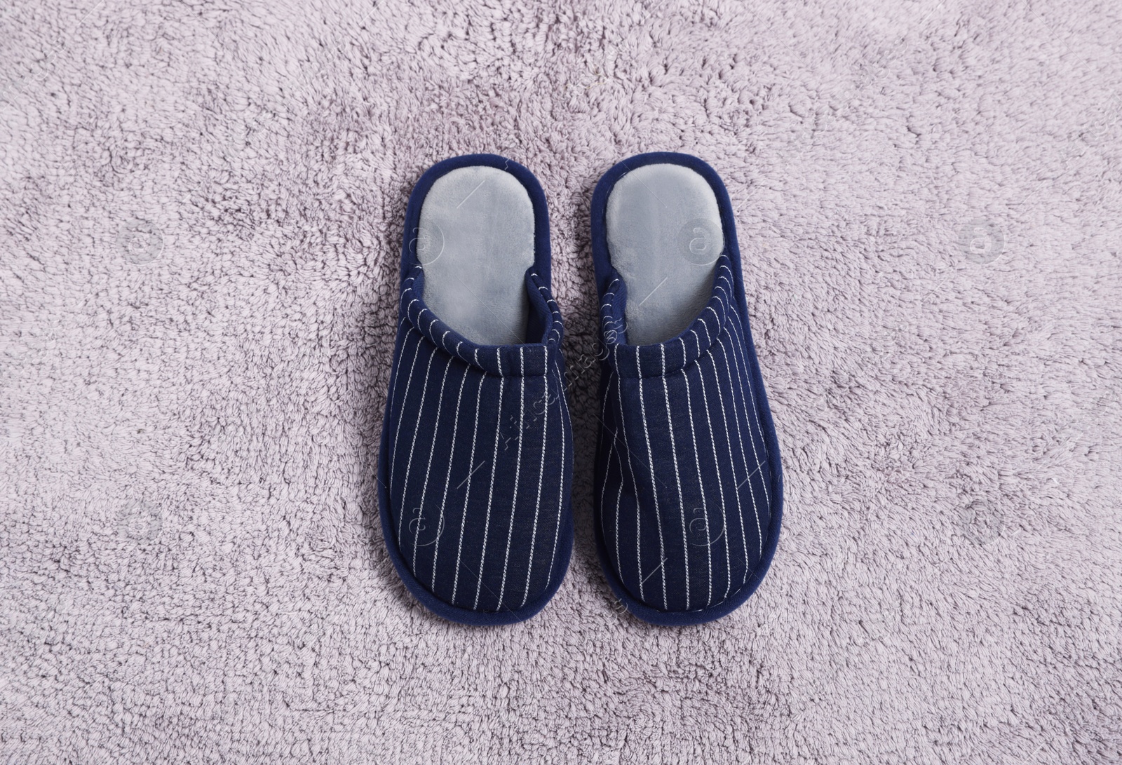 Photo of Pair of stylish slippers on light grey carpet, top view
