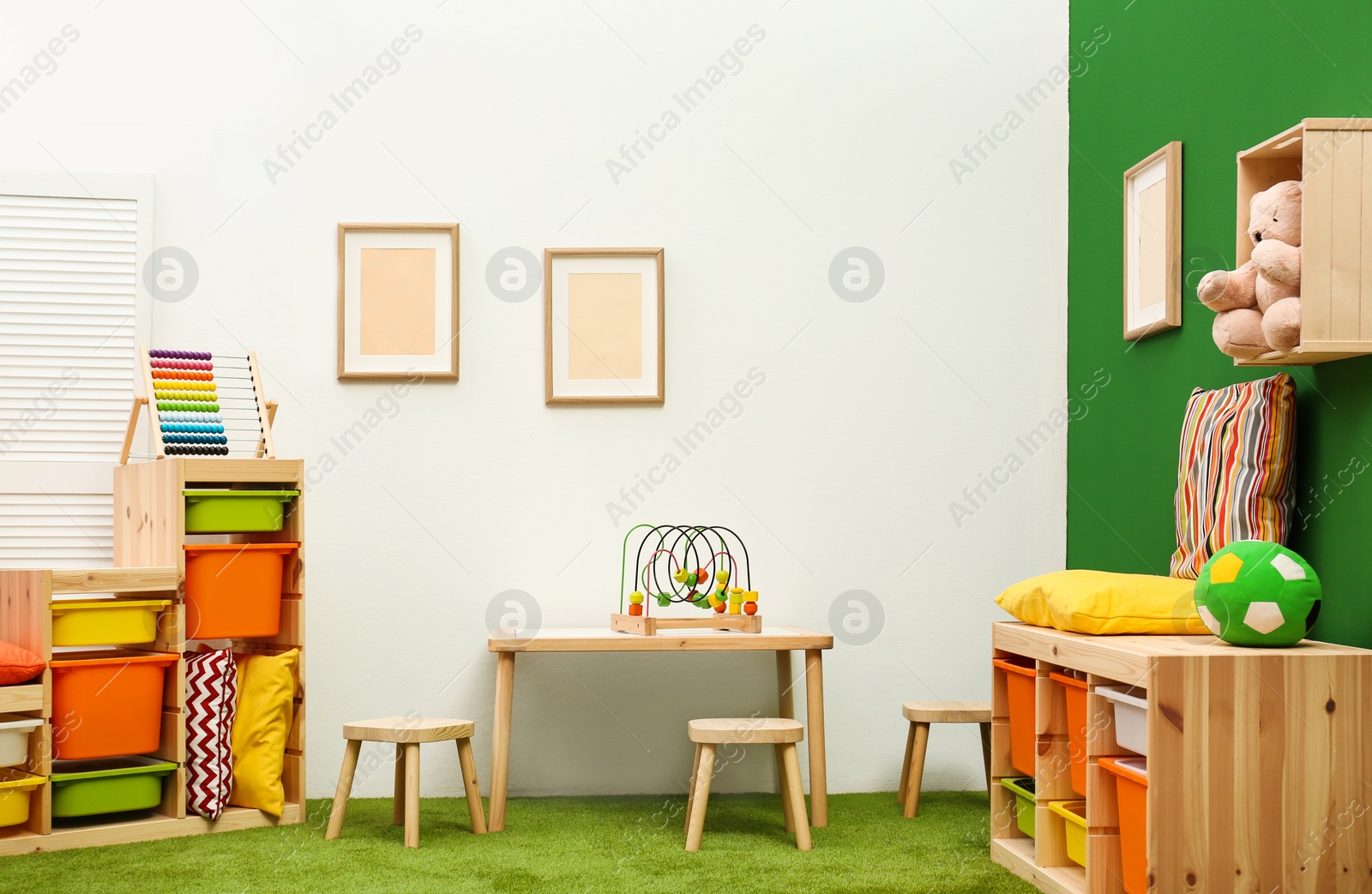 Photo of Stylish playroom interior with table and stools