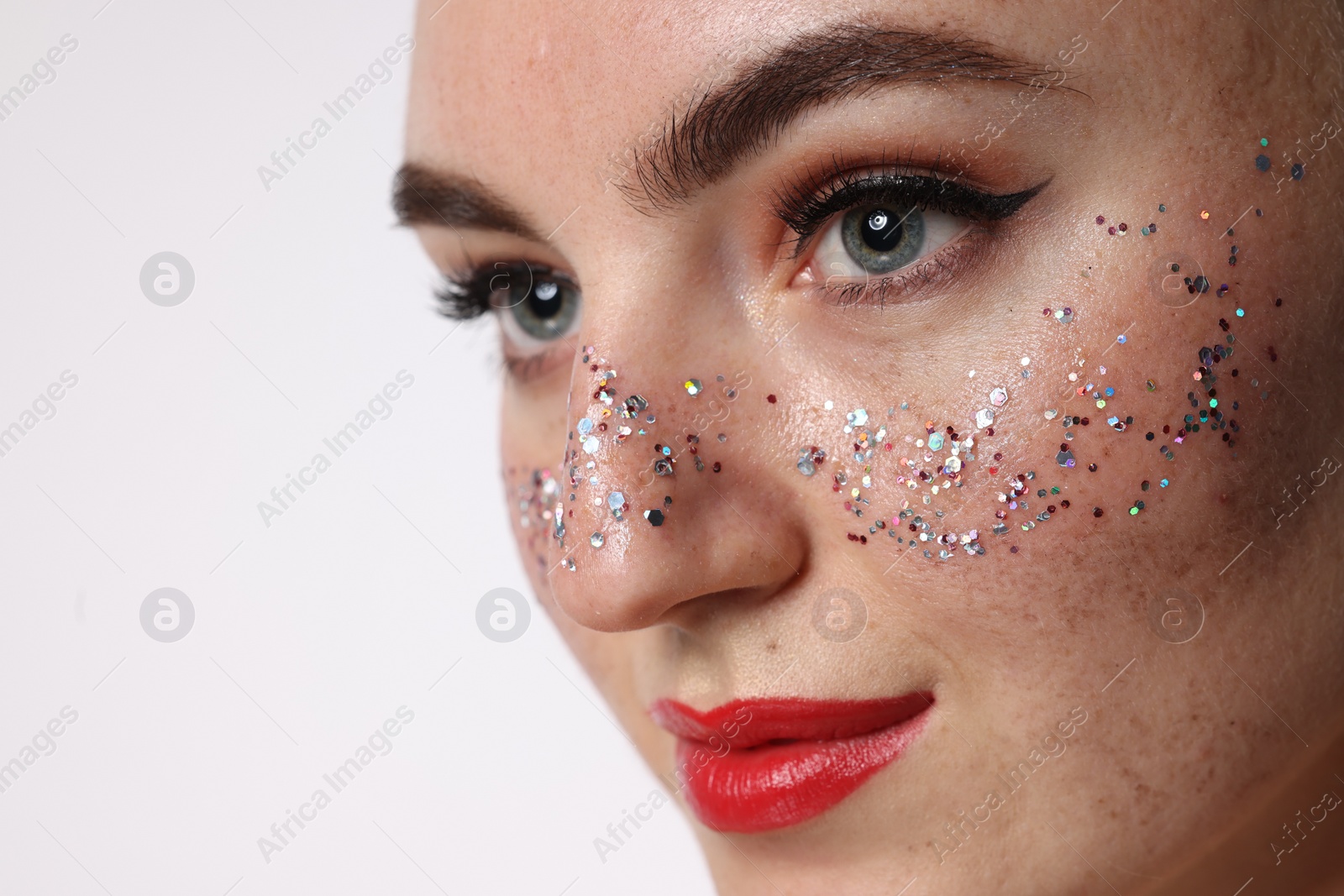 Photo of Beautiful woman with glitter freckles on white background, closeup. Space for text