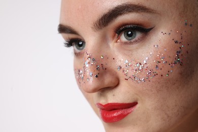 Beautiful woman with glitter freckles on white background, closeup. Space for text