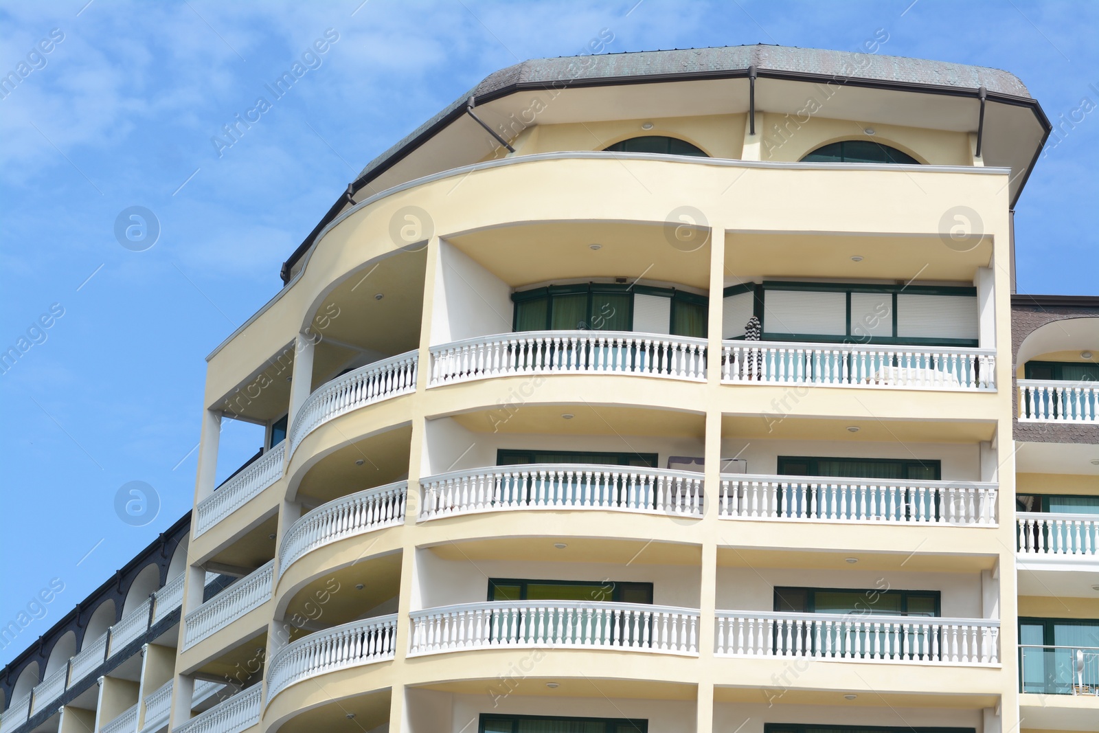 Photo of Exterior of beautiful building with balconies against blue sky