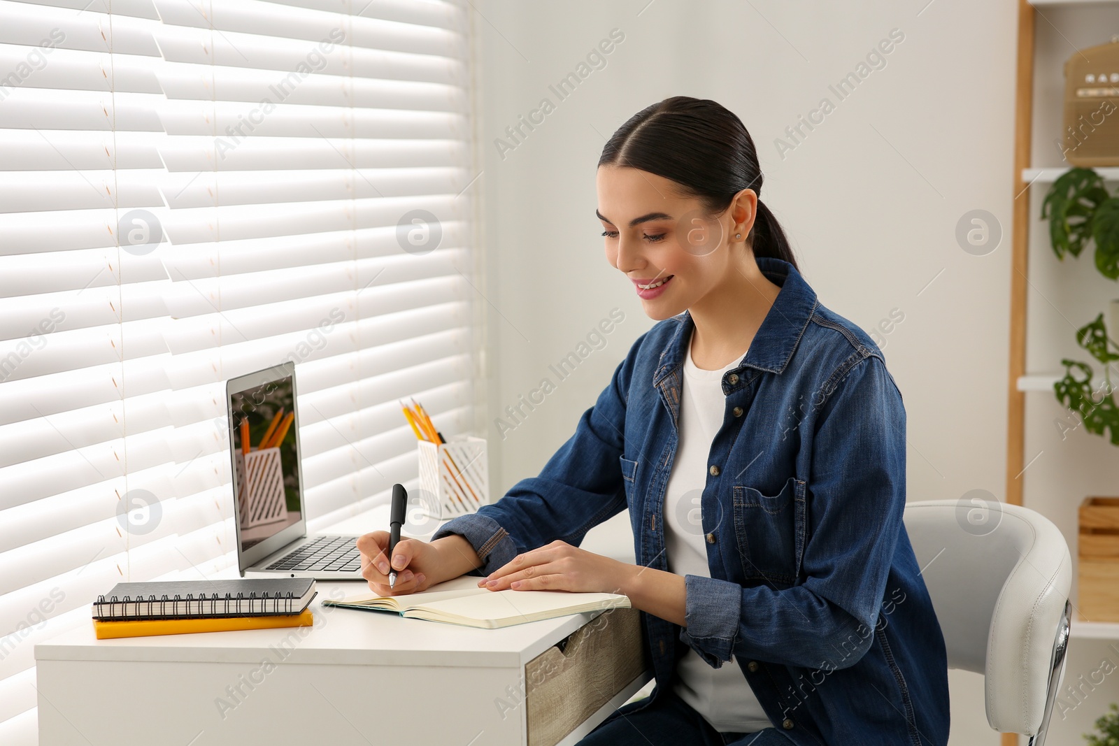 Photo of Woman studying on laptop at home. Online translation course