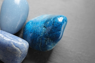 Photo of Beautiful blue gemstones on grey table, closeup view