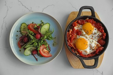 Tasty Shakshouka served on white marble table, flat lay