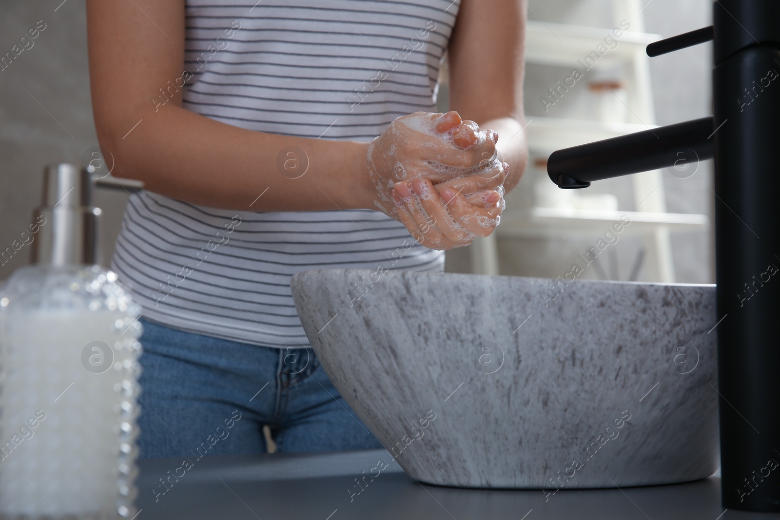 Photo of Woman washing hands with liquid soap in bathroom, closeup