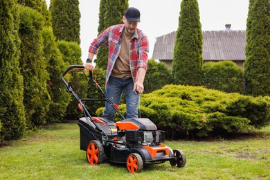 Man with modern lawn mower in garden