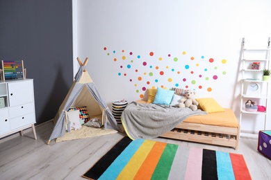 Photo of Modern child room interior with bed and play tent