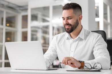 Smiling man working at table in office. Lawyer, businessman, accountant or manager