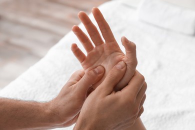 Photo of Woman receiving hand massage in wellness center, closeup