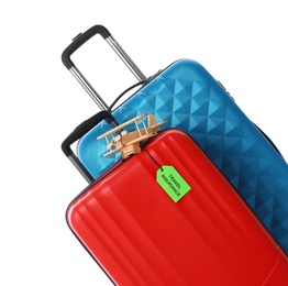 Photo of Red and blue suitcases with TRAVEL INSURANCE label on white background