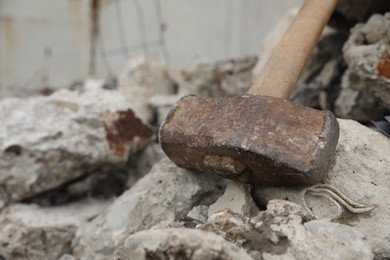 Sledgehammer on of broken stones outdoors, closeup. Space for text