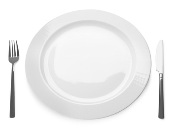 Photo of Empty plate and cutlery on white background. Table setting