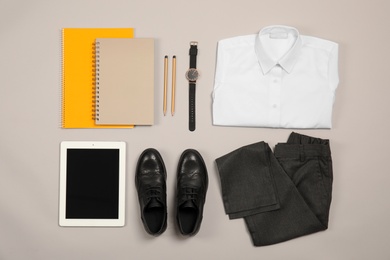 Photo of Composition with school uniform for boy and tablet on grey background, top view