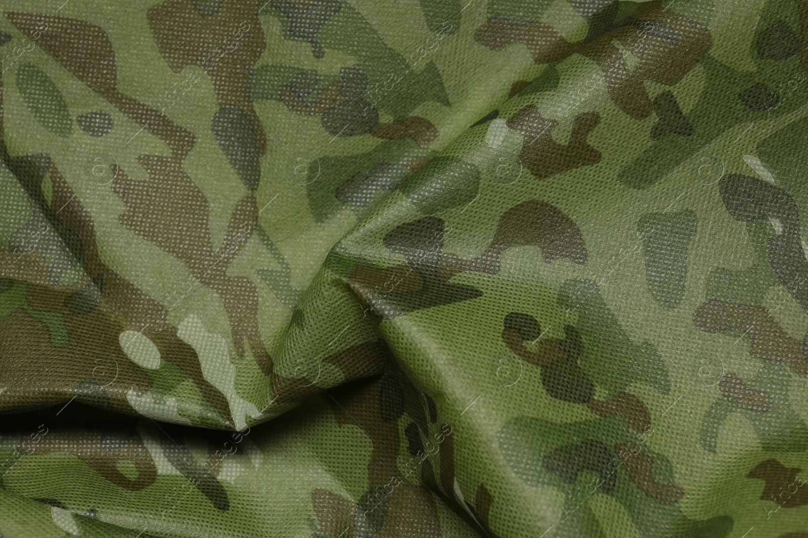 Photo of Texture of crumpled camouflage fabric as background, top view