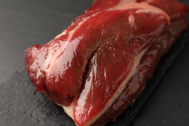 Piece of raw beef meat on black table, closeup