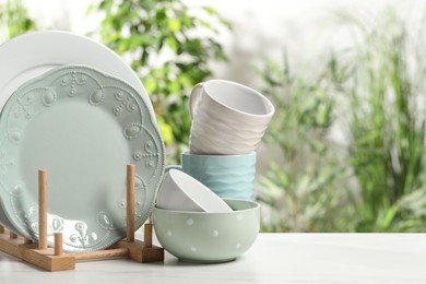 Photo of Beautiful ceramic dishware and cup on white marble table outdoors, space for text