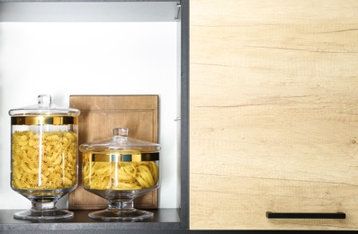 Photo of Products in modern kitchen glass containers on shelf