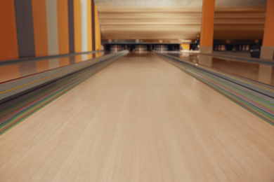 Photo of Empty wooden alley lane in modern bowling club