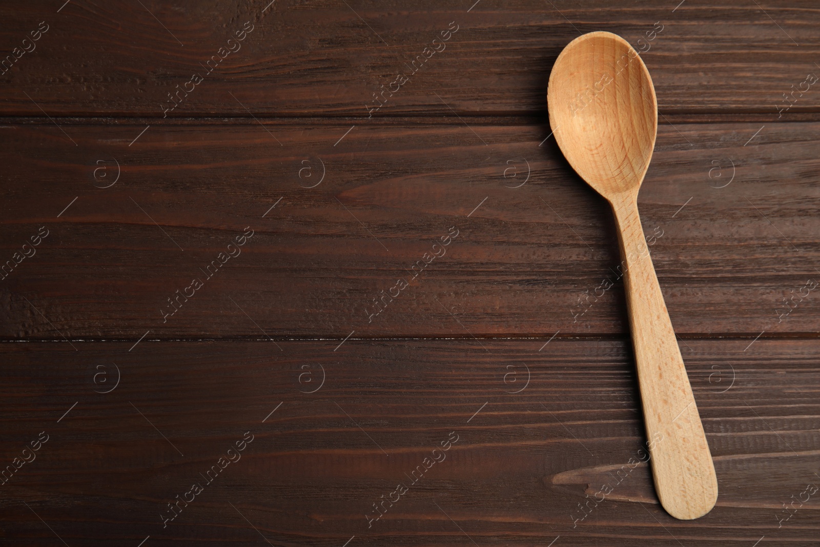 Photo of Handmade wooden spoon on rustic table, top view. Space for text