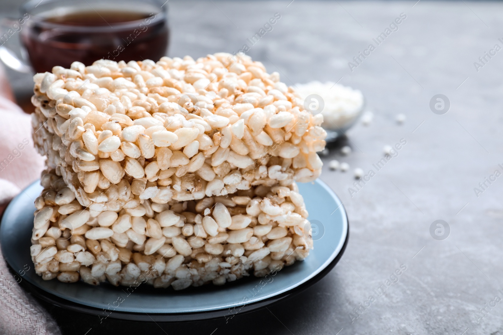 Photo of Delicious rice crispy treats on grey table, closeup