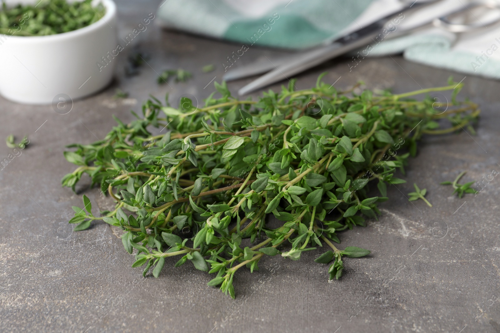 Photo of Bunch of aromatic thyme on grey table, closeup