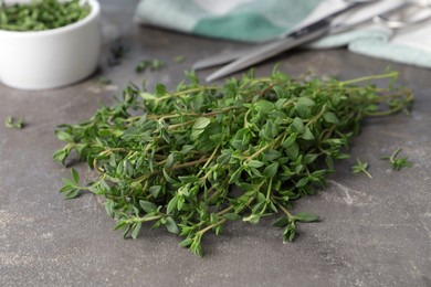 Photo of Bunch of aromatic thyme on grey table, closeup