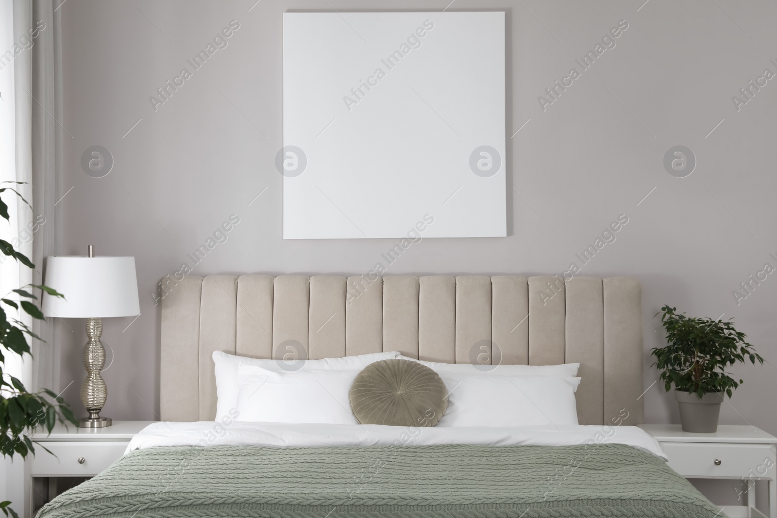 Photo of Blank canvas on wall in stylish bedroom interior. Space for design