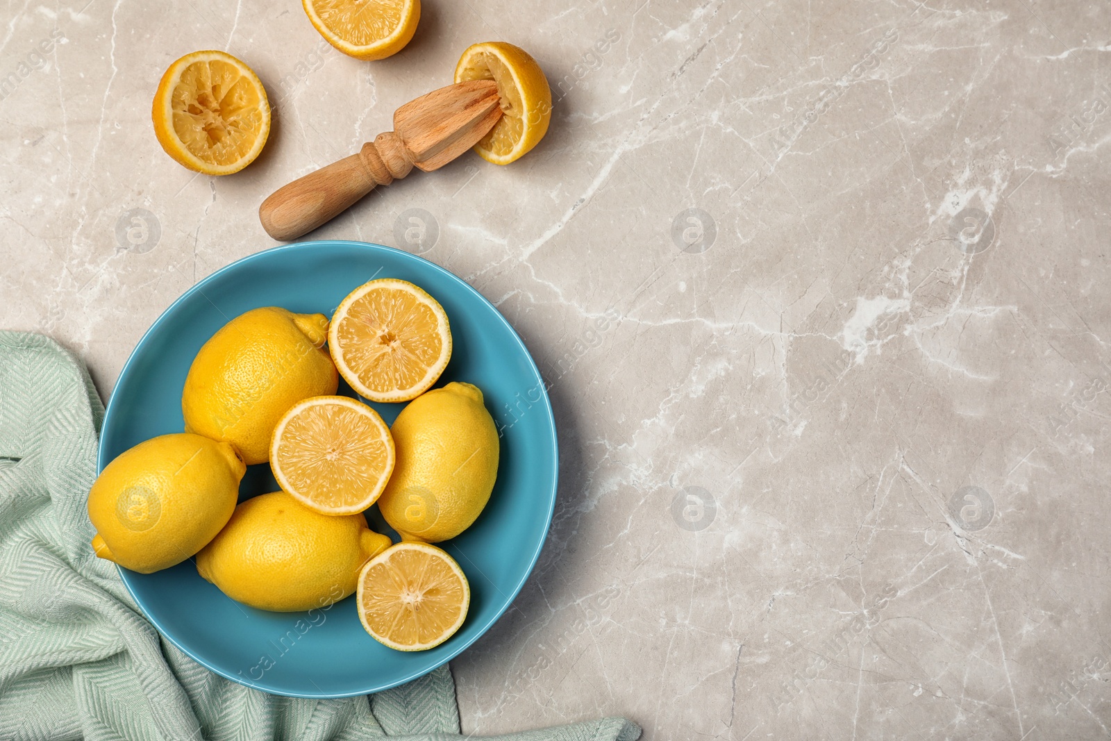 Photo of Composition with fresh lemons and wooden reamer on table, top view. Space for text