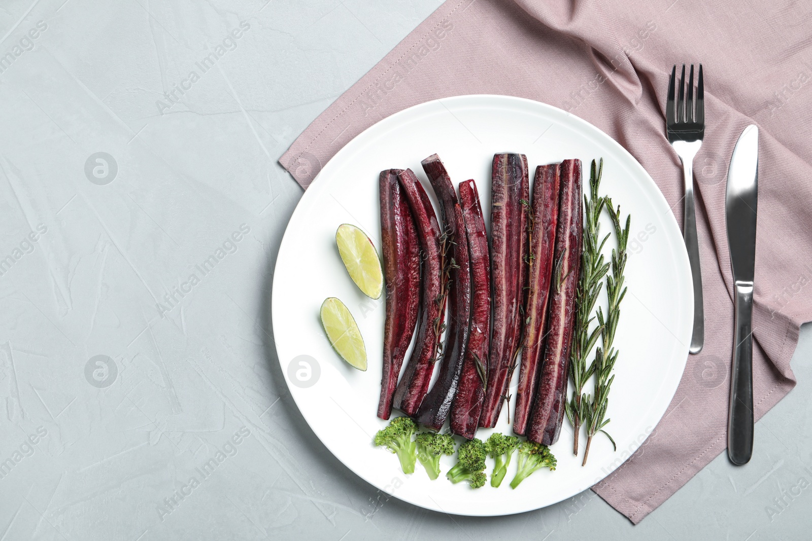 Photo of Flat lay composition with raw black carrot served on light grey table