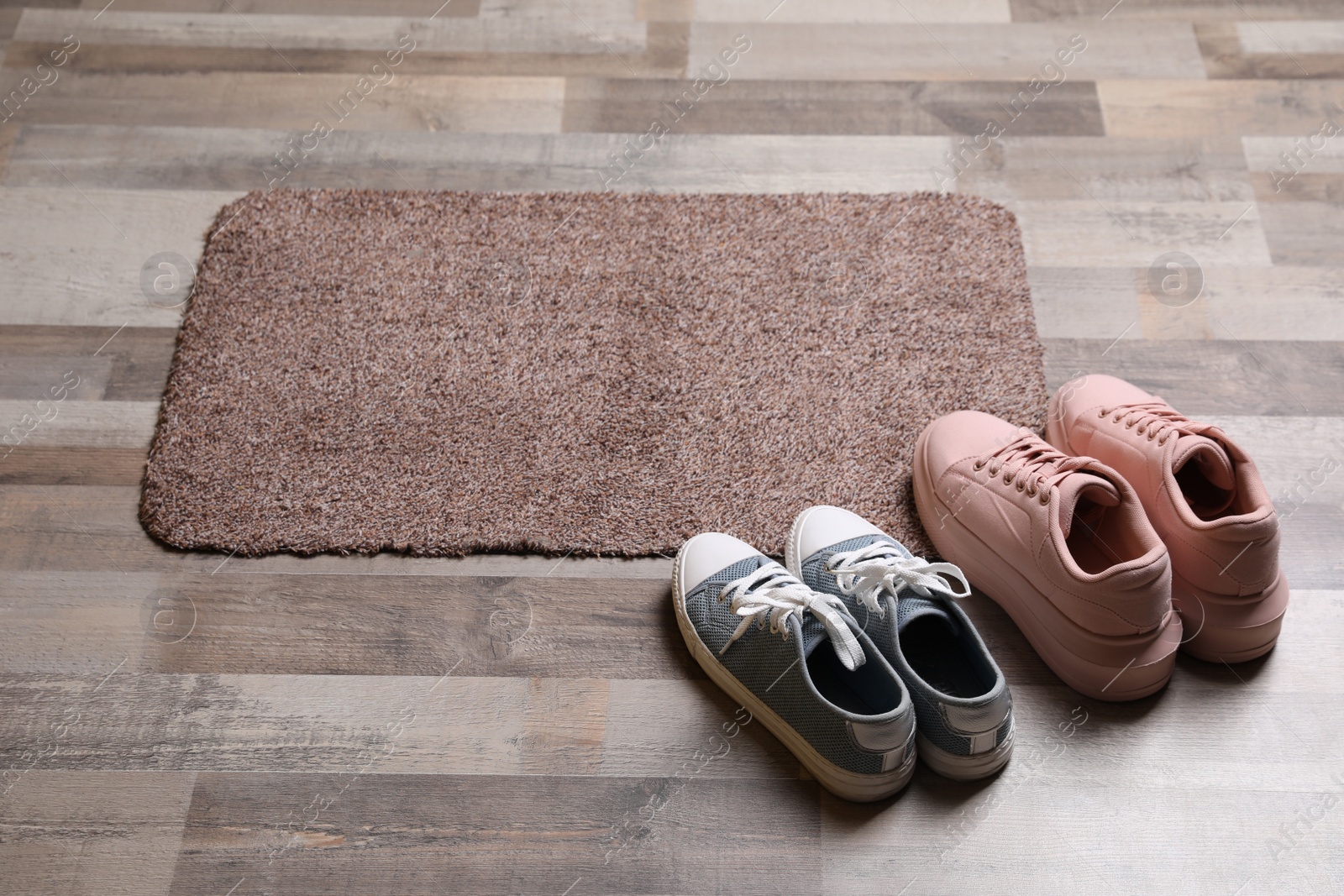 Photo of New clean door mat and shoes on floor