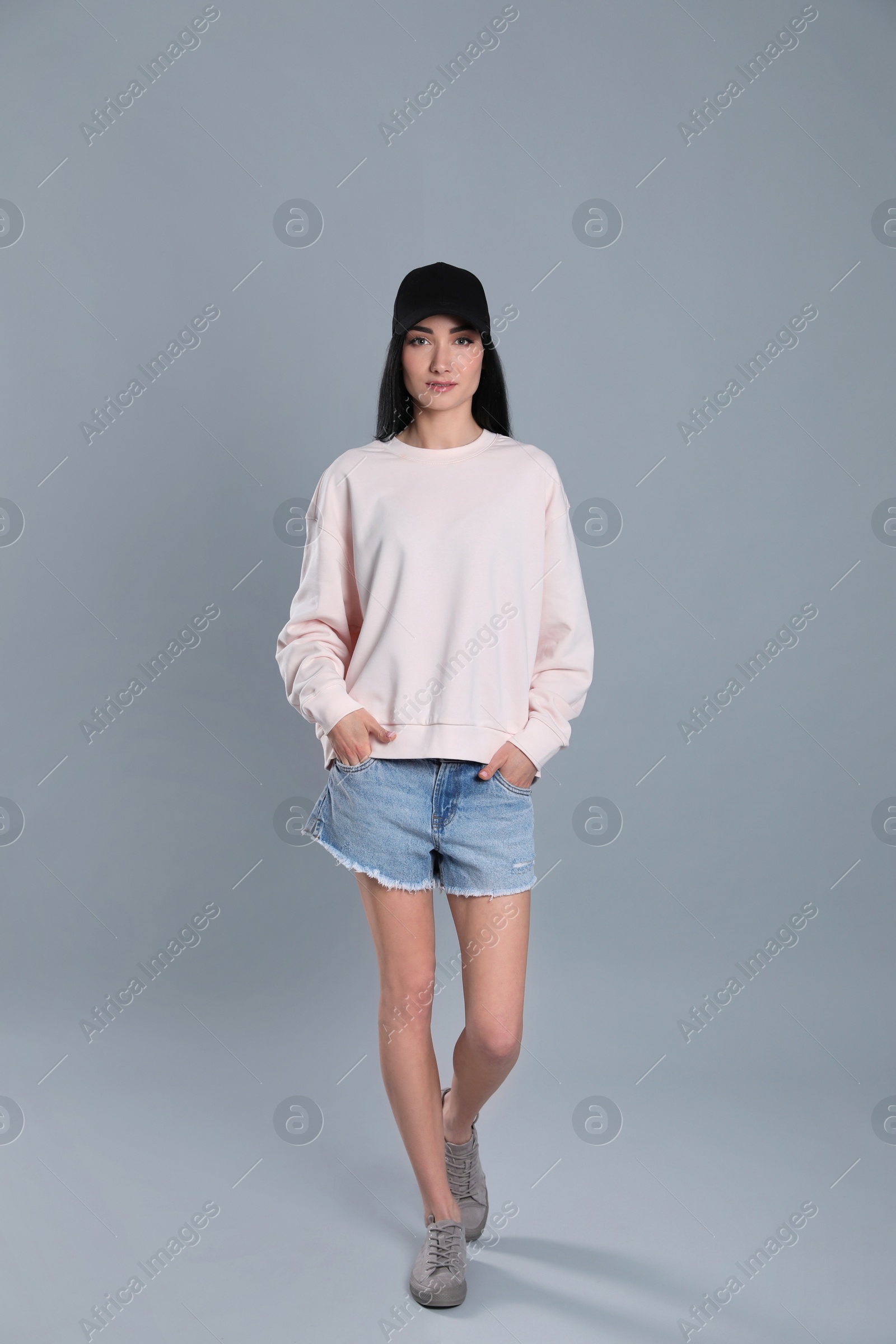 Photo of Full length portrait of young woman in sweater on grey background. Mock up for design