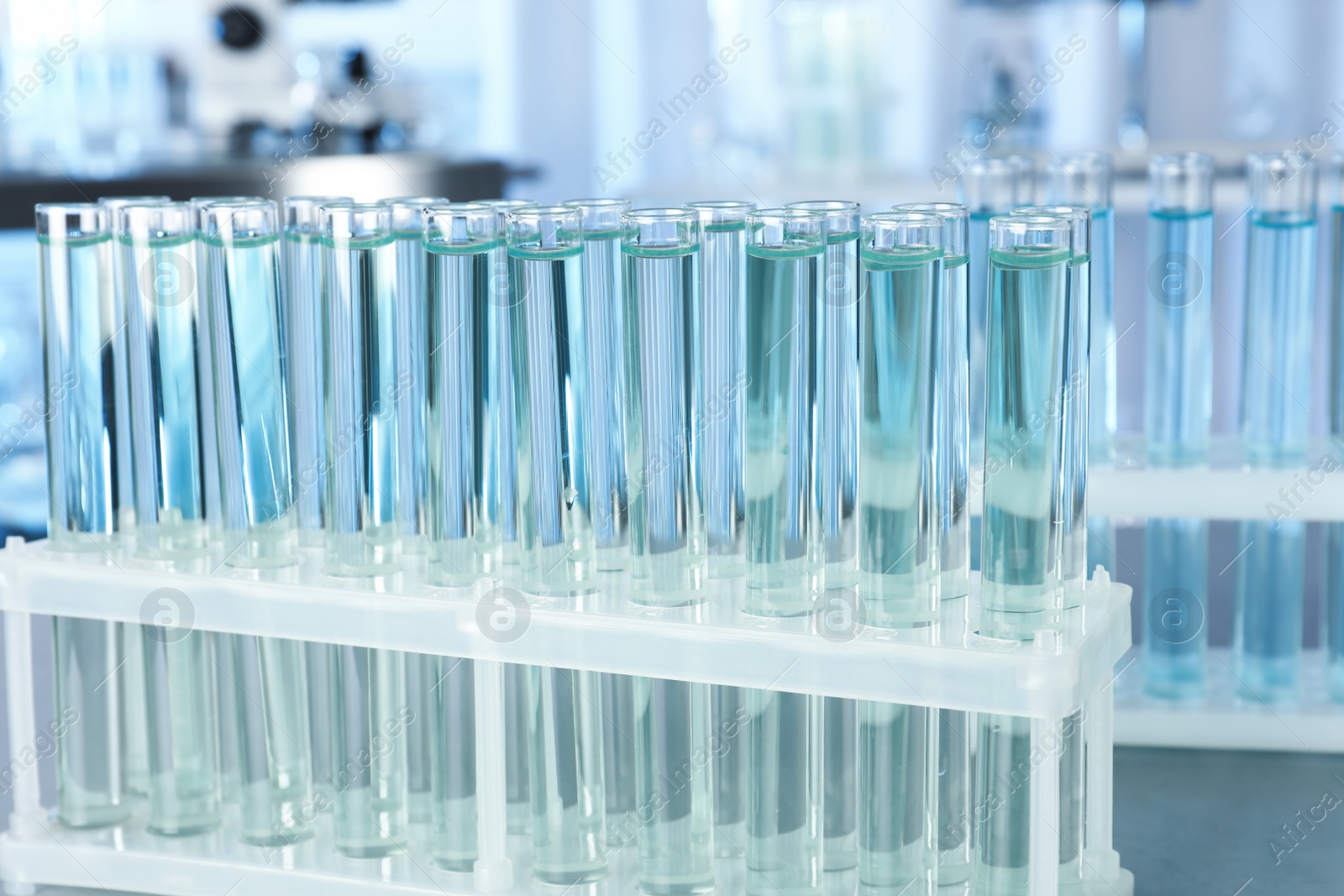 Photo of Test tubes with liquid on blurred background. Laboratory analysis