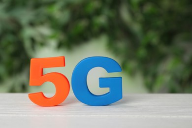 Photo of 5G technology, Internet concept. Number and letter on white wooden table