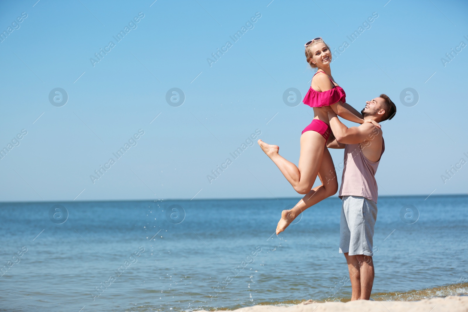 Photo of Happy young couple having fun at beach on sunny day