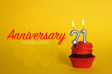 Image of Delicious cupcake with number shaped candles on yellow background. Coming of age party - 21th birthday. Anniversary celebration