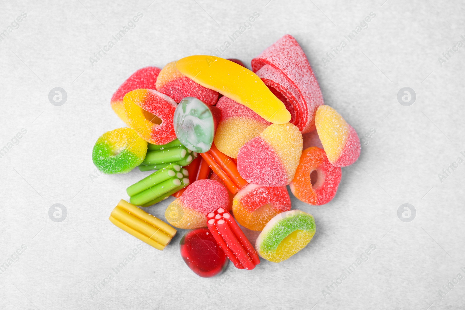 Photo of Pile of tasty colorful jelly candies on white table, flat lay