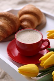 Photo of Morning coffee, flowers and croissants on white wooden tray