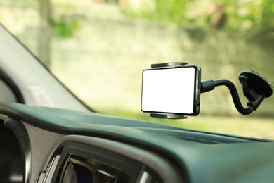 Photo of Car holder with modern mobile phone on windshield of automobile. Mockup for design